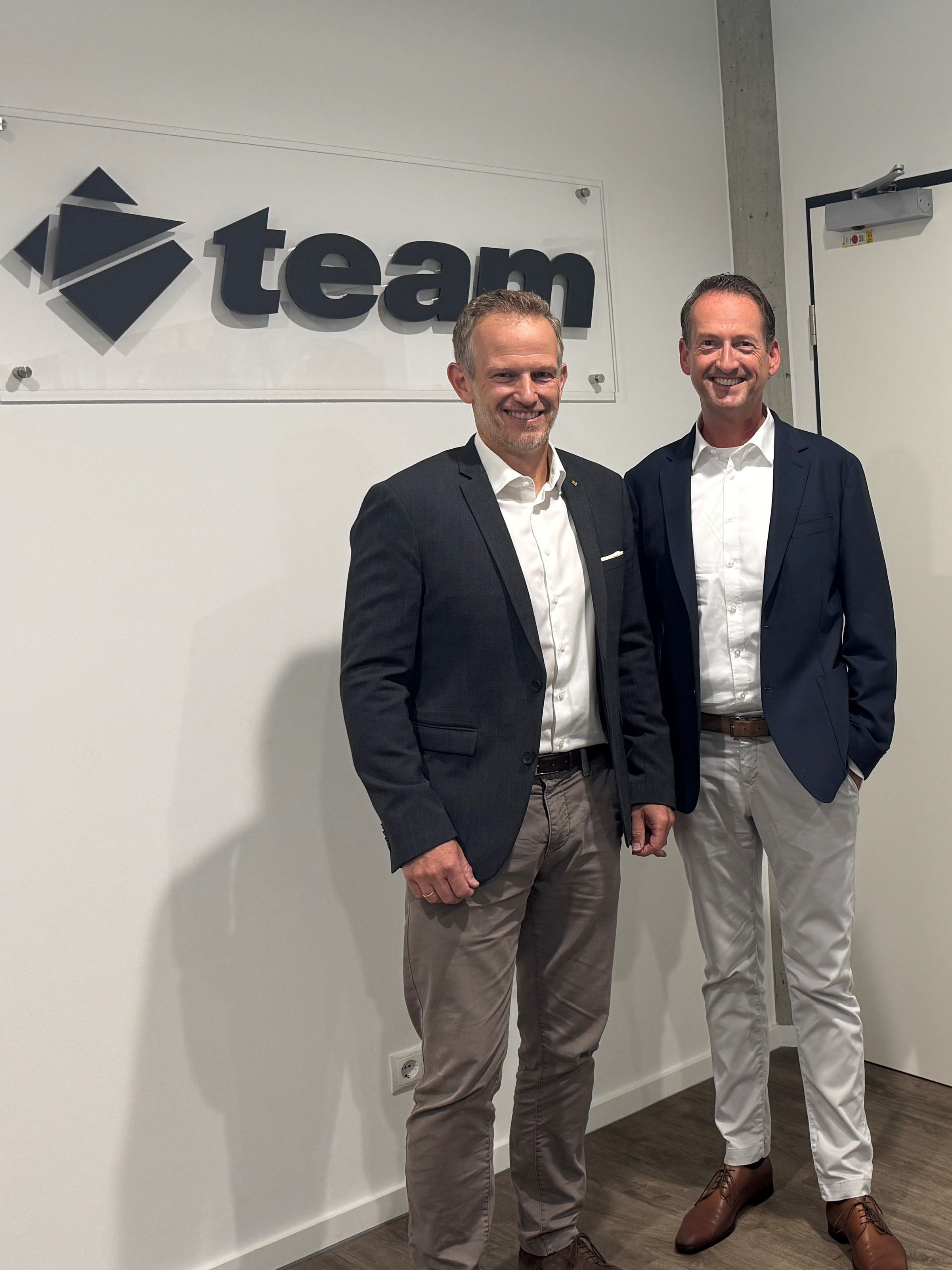 Markus Präßl and Kevin Lorenzen in front of a team logo.