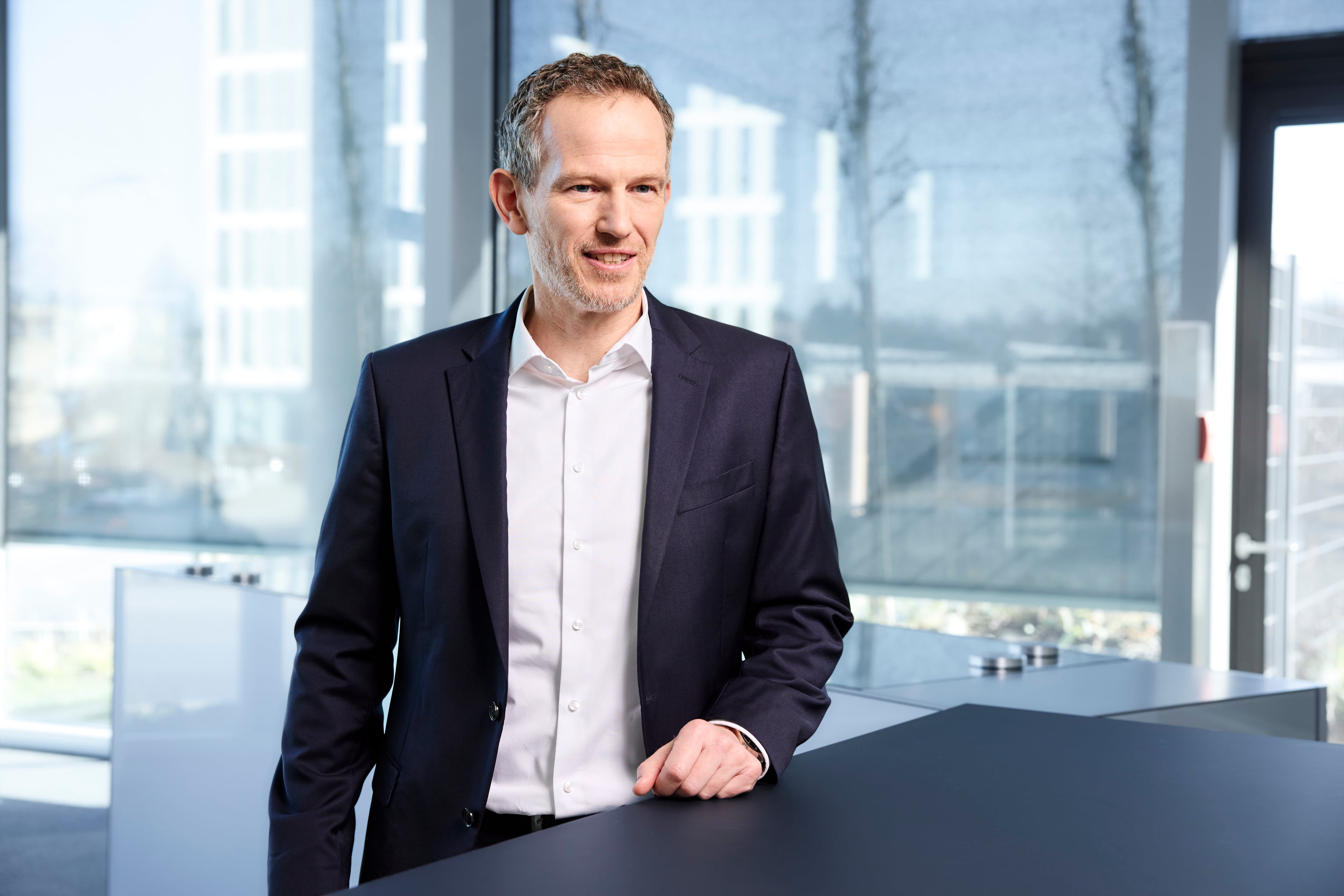 Markus Präßl standing at a desk.